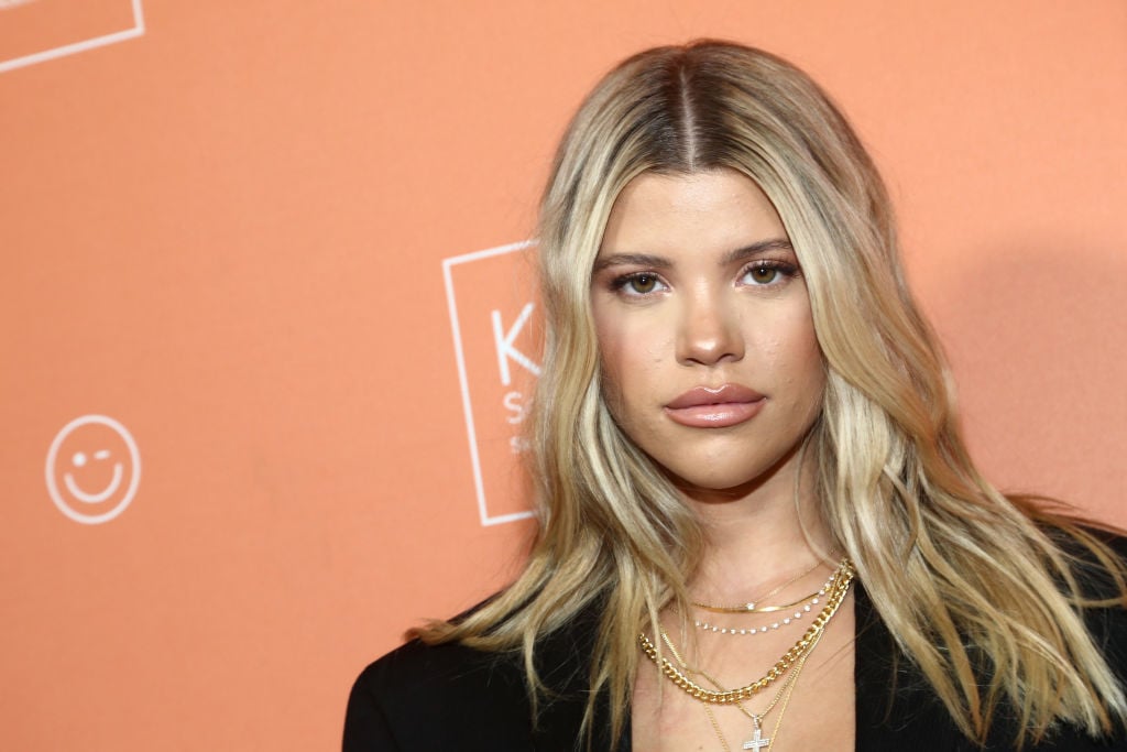 Sofia Richie looking into the camera in front of an orange background