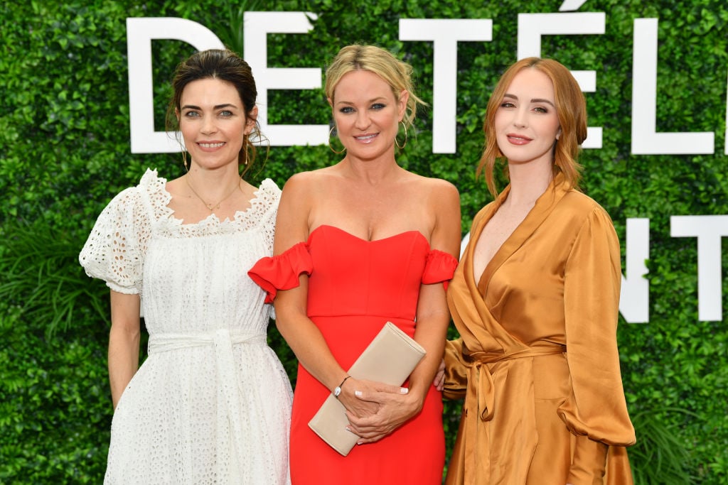 Amelia Heinle, Sharon Case and Camryn Grimes smiling in front of a green background