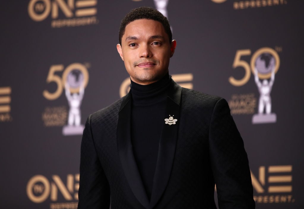 Trevor Noah in front of a repeating background