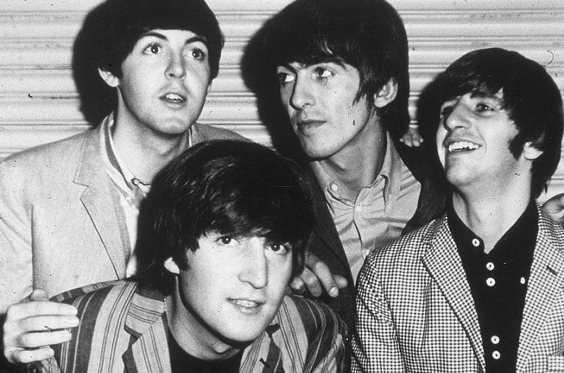 The Beatles smile for the camera in 1965.