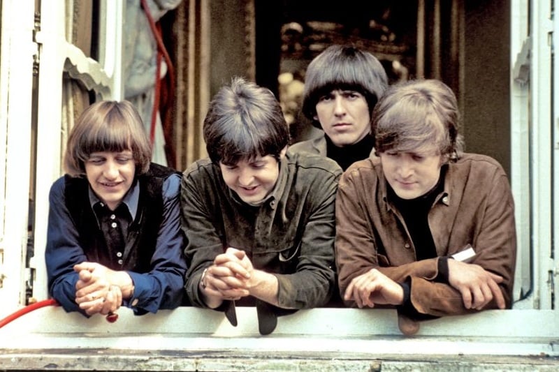 The Beatles stand at a window while filming 'Help'