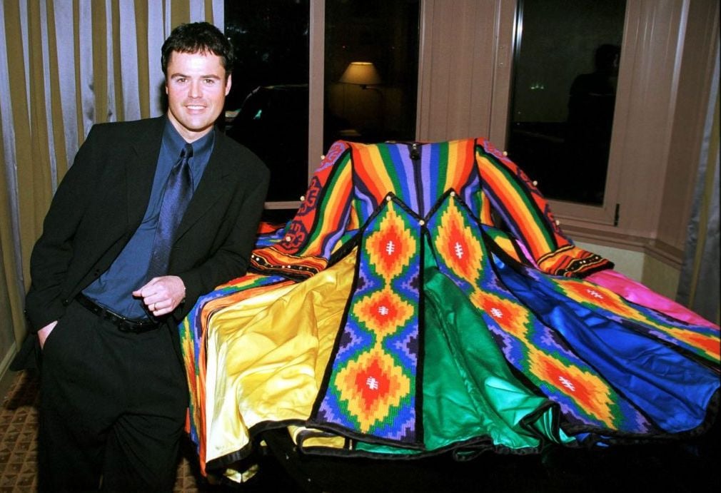 Donny Osmond poses next to the "Dreamcoat" during a reception for the Universal Studios Home Video release of 'Joseph and the Amazing Technicolor Dreamcoat,' February 13, 2000.