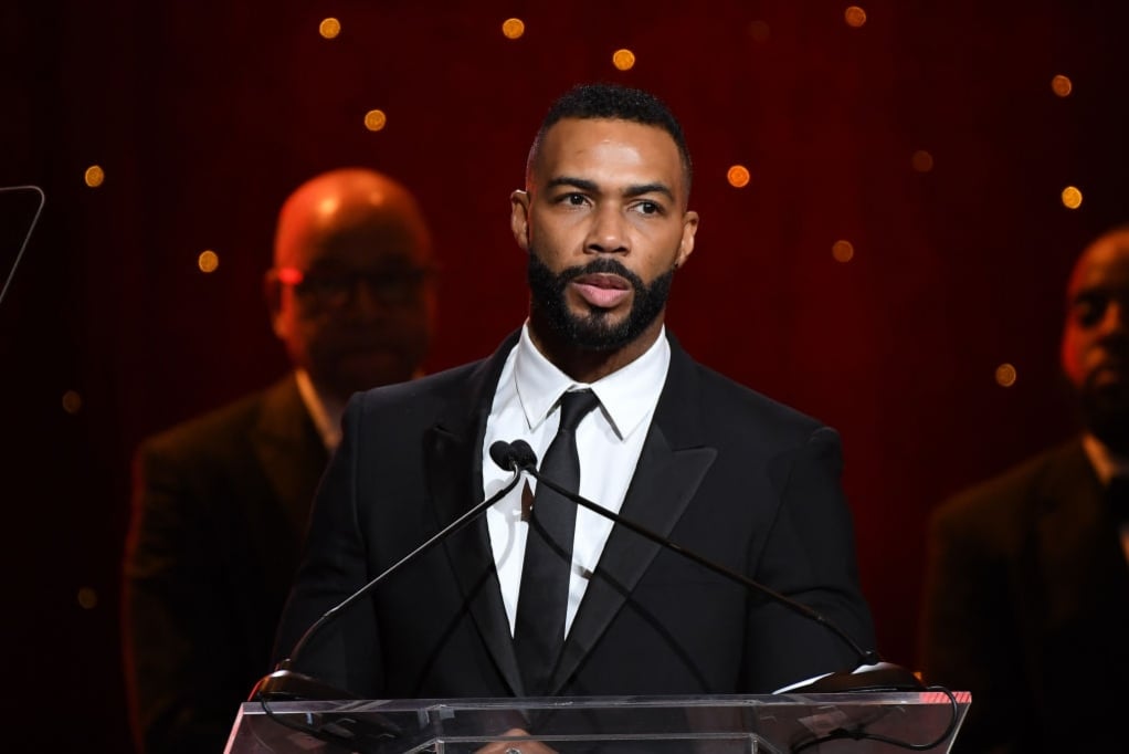 Omari Hardwick speaking onstage at a media event