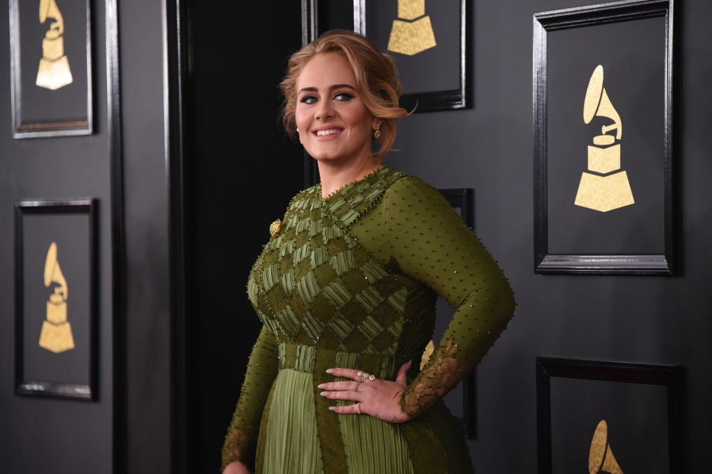Adele smiling, turned towards the side, in a green dress