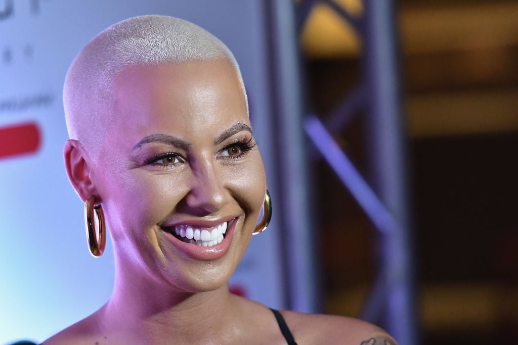 Amber Rose smiling in front of a repeating background