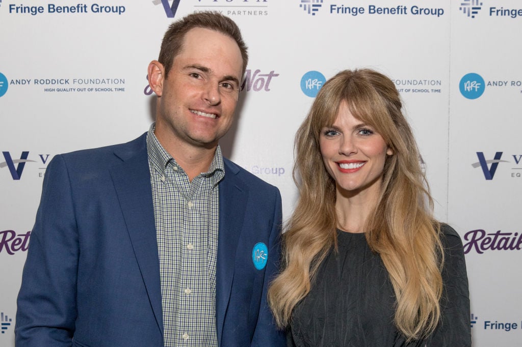 Andy Roddick and Brooklyn Decker smiling in front of a repeating background