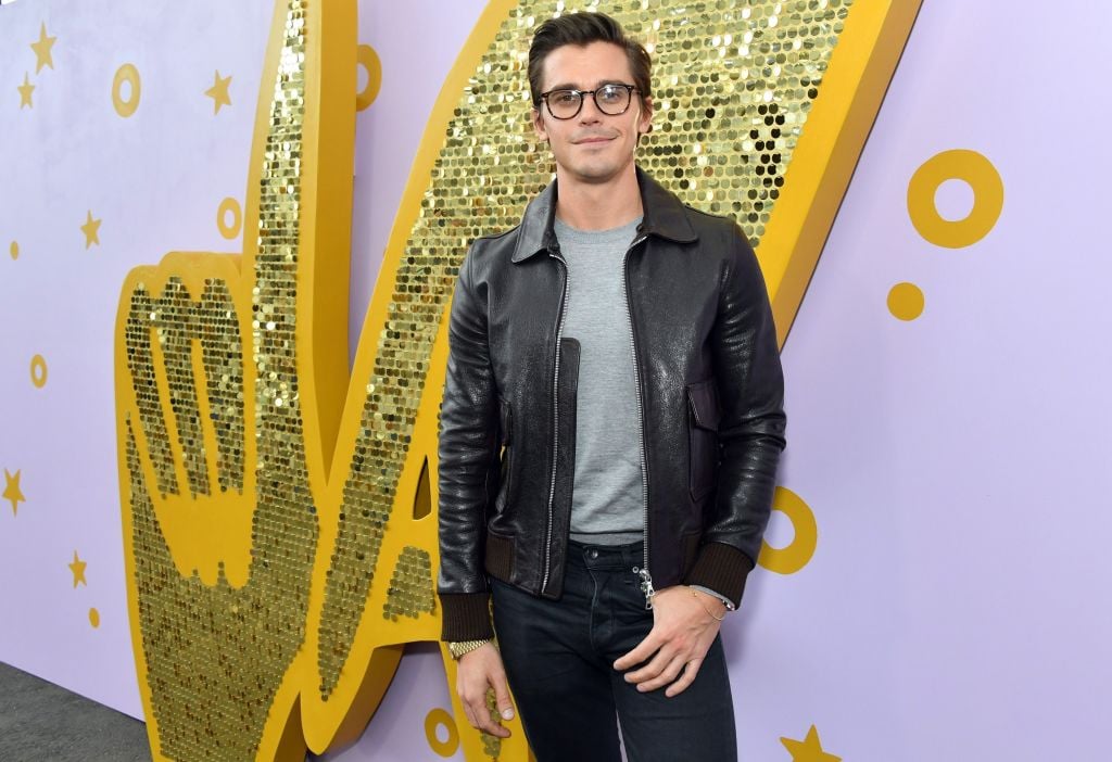 Antoni Porowski smiling at the camera in front of a sparkling background