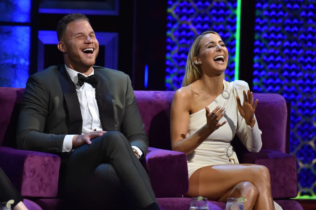 Blake Griffin and Nikki Glaser sitting next to each other on stage laughing