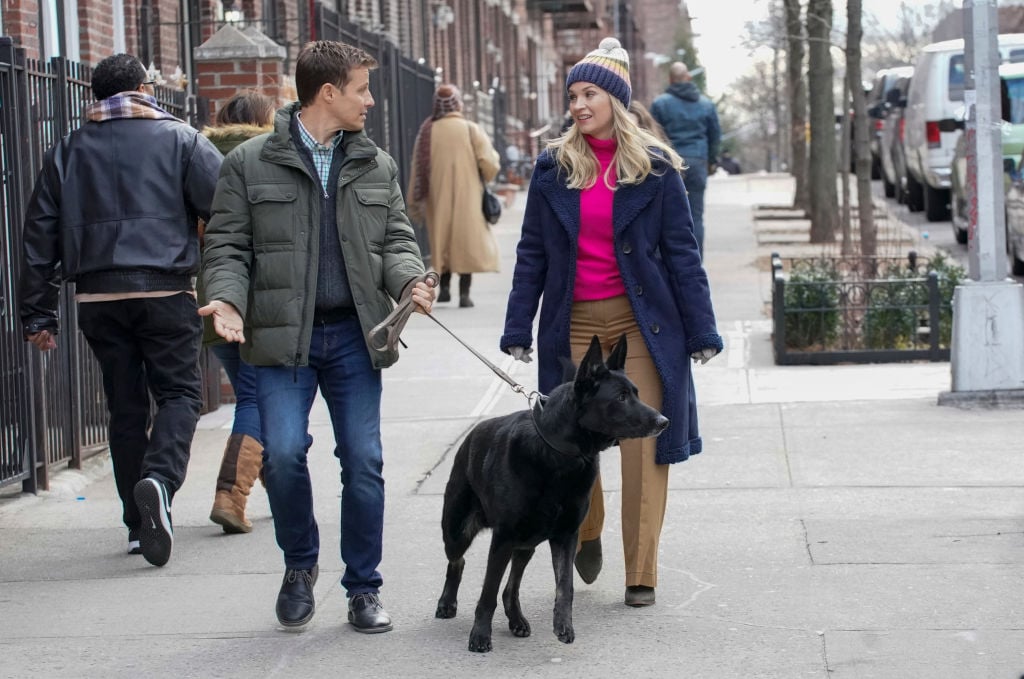 Jamie Reagan (Will Estes) and Eddie Janko (Vanessa Ray) walking a black dog