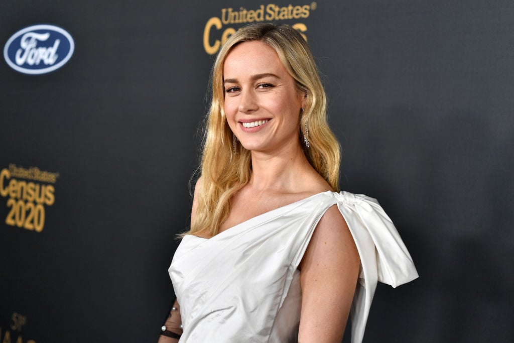 Brie Larson smiling, turned slightly to the side wearing white