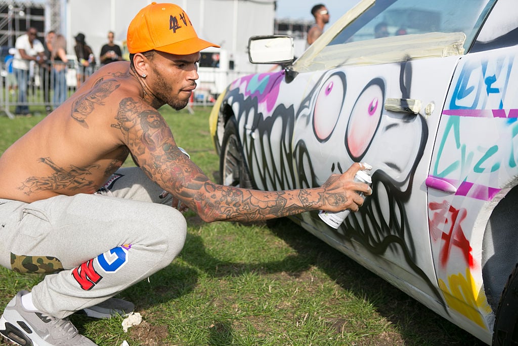 Chris Brown spray painting a car