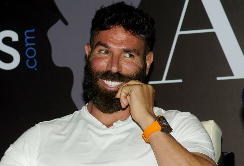 Dan Bilzerian smiling with his hand near his mouth