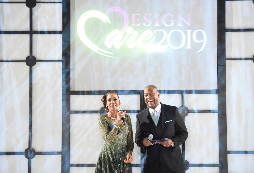 Holly Robinson Peete and Rodney Peete smiling and laughing on a stage