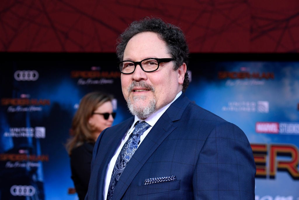 Jon Favreau smiling in a navy suit