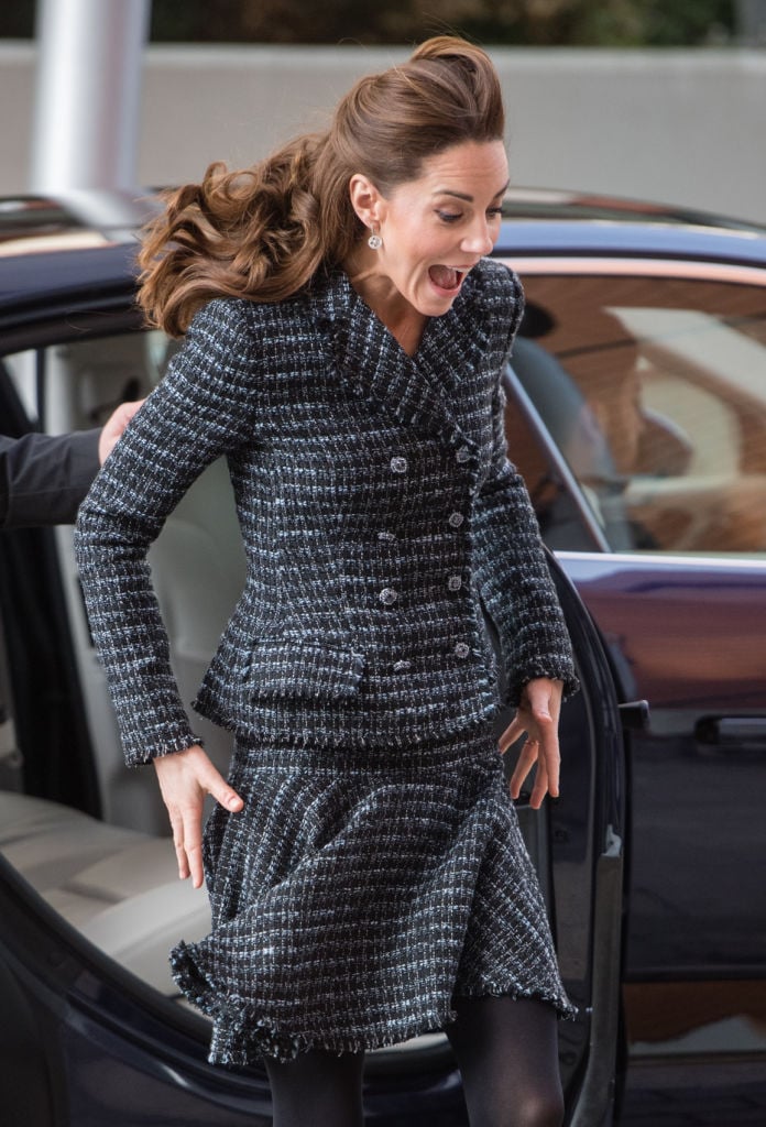 Kate Middleton holds her skirt down as she gets out of a car