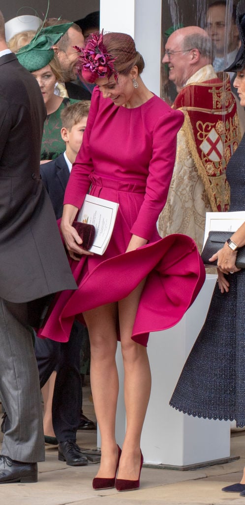Kate Middleton keeps her dress from blowing in the wind
