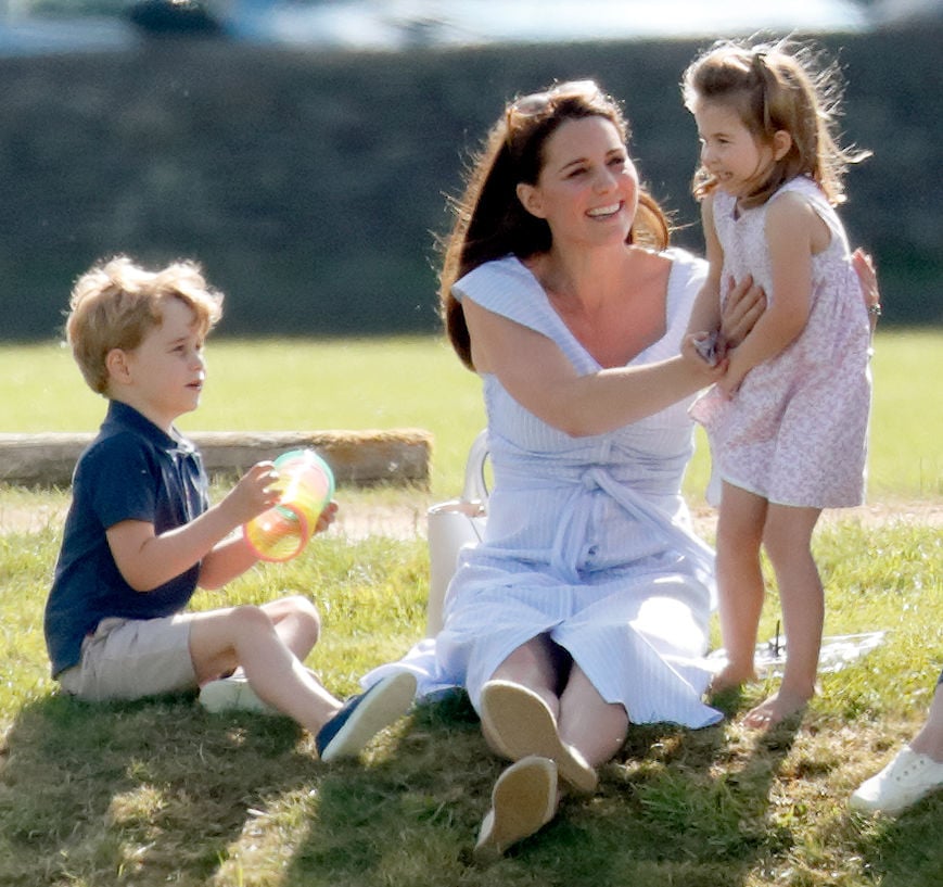 Kate Middleton sits with her children, Prince George and Princess Charlotte, at a charity polo match in 2018