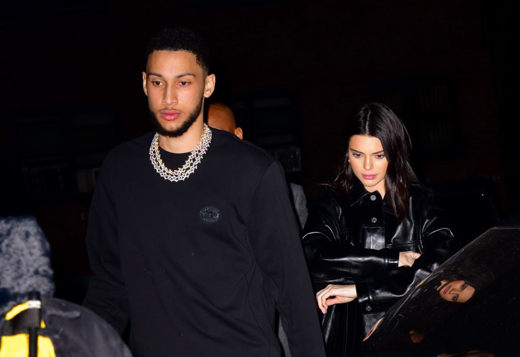 Ben Simmons looking off camera and Kendall Jenner slightly behind him looking down with arms crossed