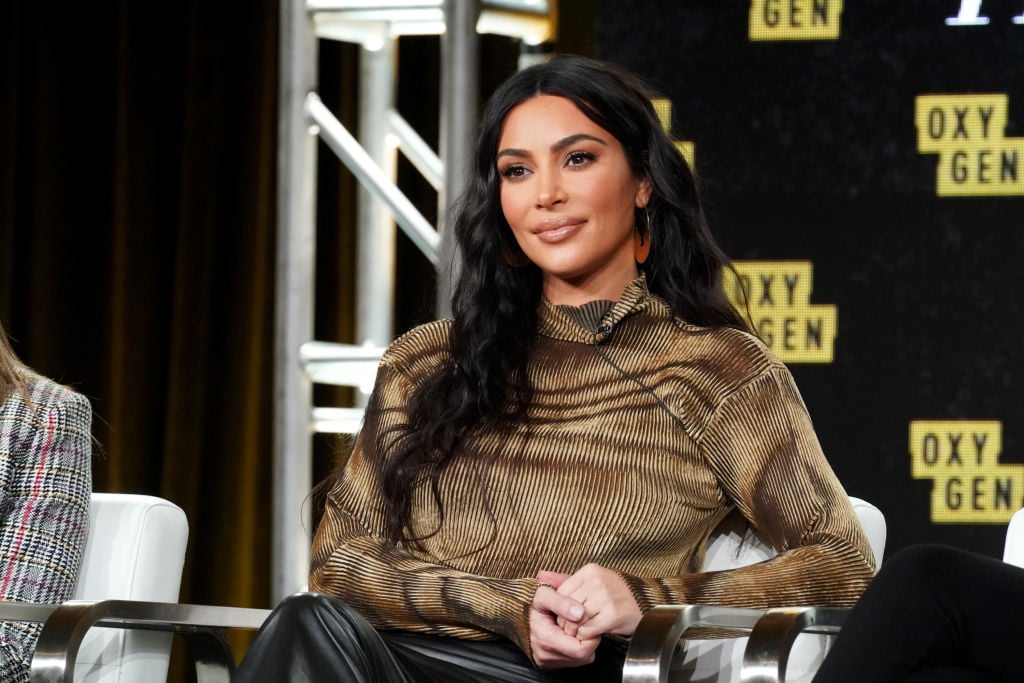 Kim Kardashian West smiling while sitting on a stage