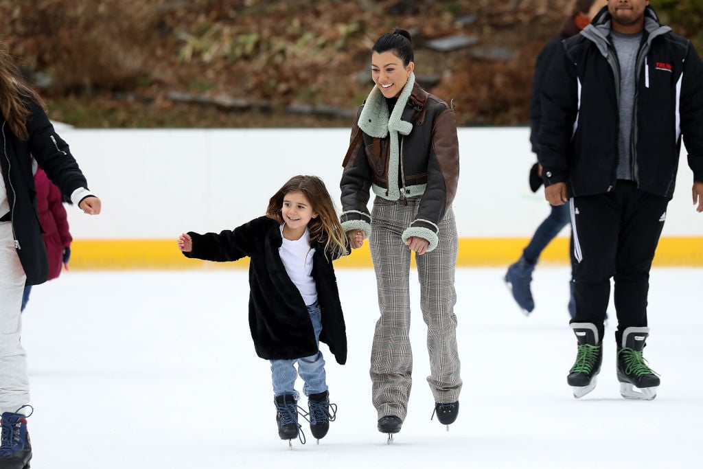 Kourtney Kardashian and Penelope Disick smiling while ice skating in central park
