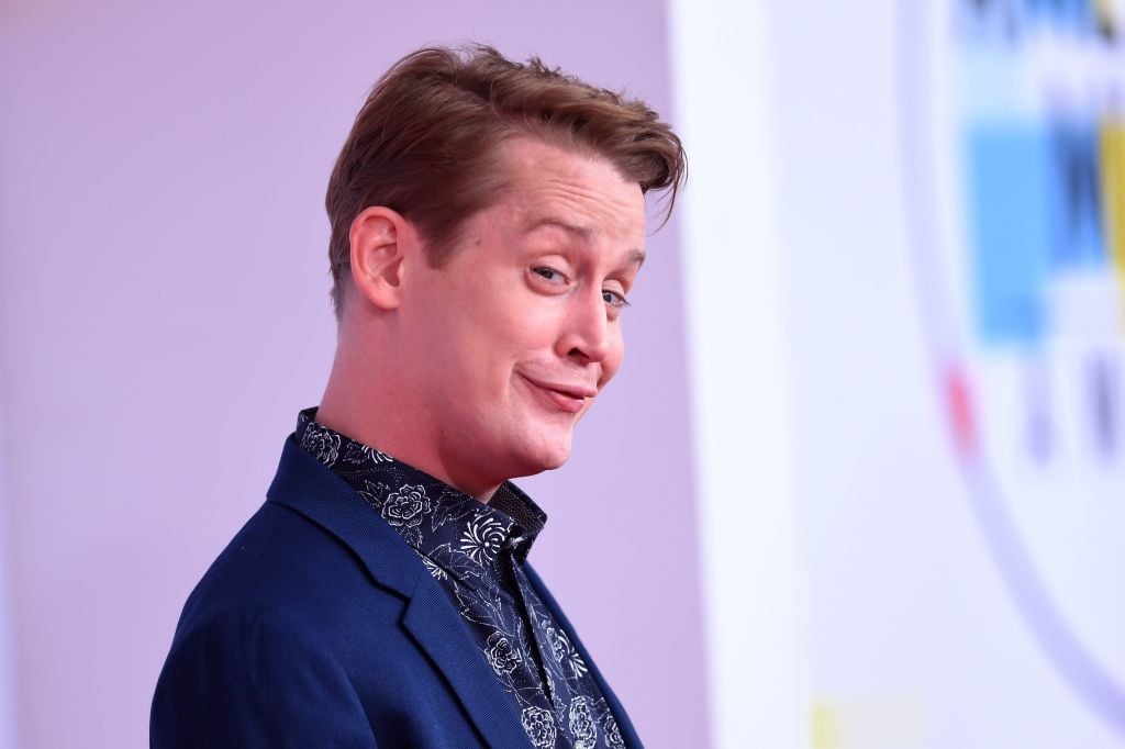 Macaulay Culkin smirking, looking to the side