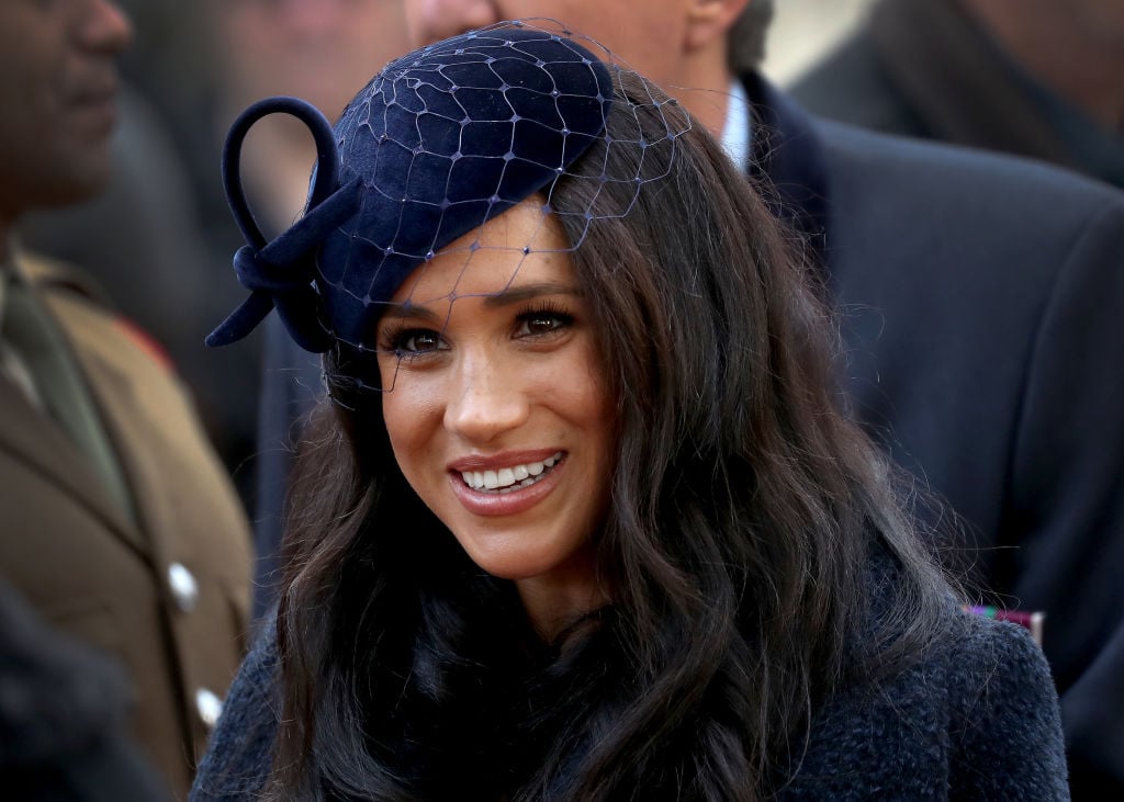 Meghan Markle smiling, looking away from the camera