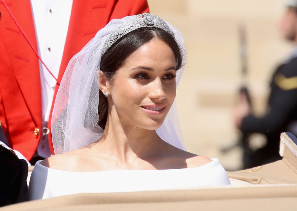 Meghan Markle smiling looking off camera wearing her wedding dress and veil