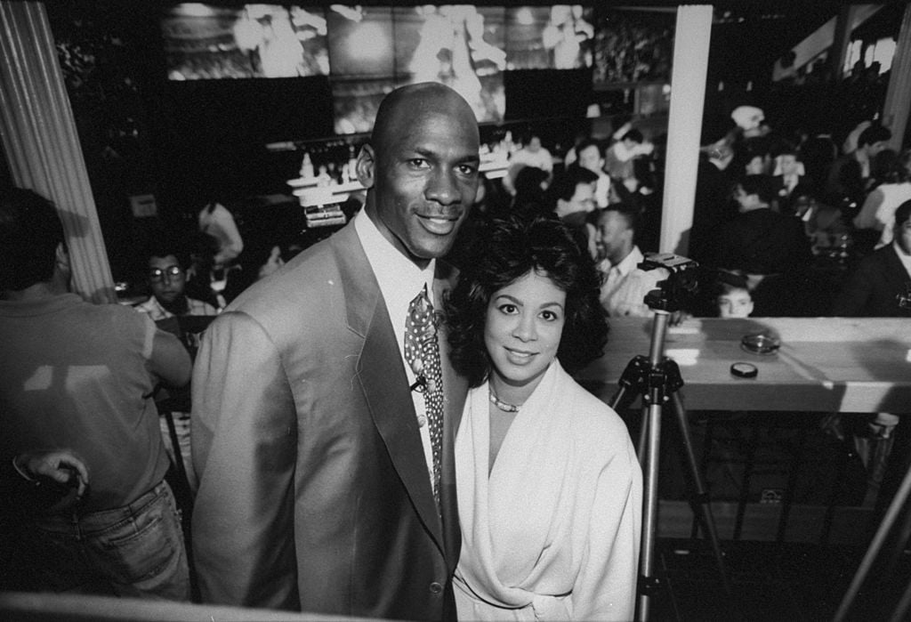 Chicago Bulls basketball star Michael Jordan posing w. wife Juanita at bar at the opening of his restaurant