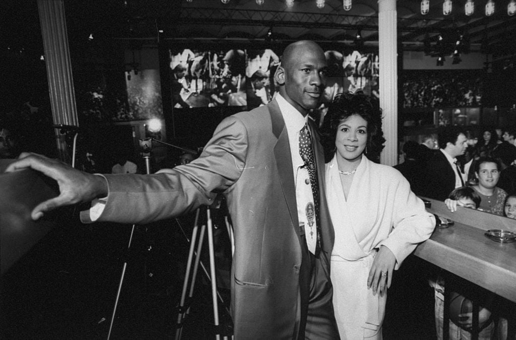 Chicago Bulls basketball star Michael Jordan posing w. wife Juanita at bar at the opening of his restaurant