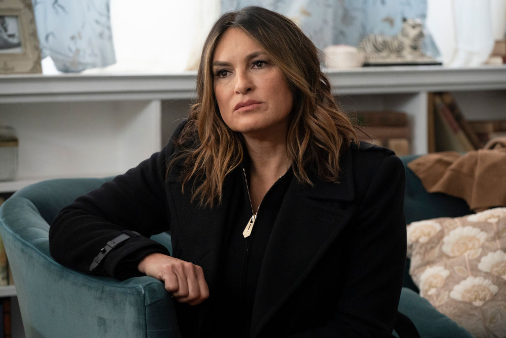 Mariska Hargitay as Captain Olivia Benson in all black sitting on a couch, looking away from the camera