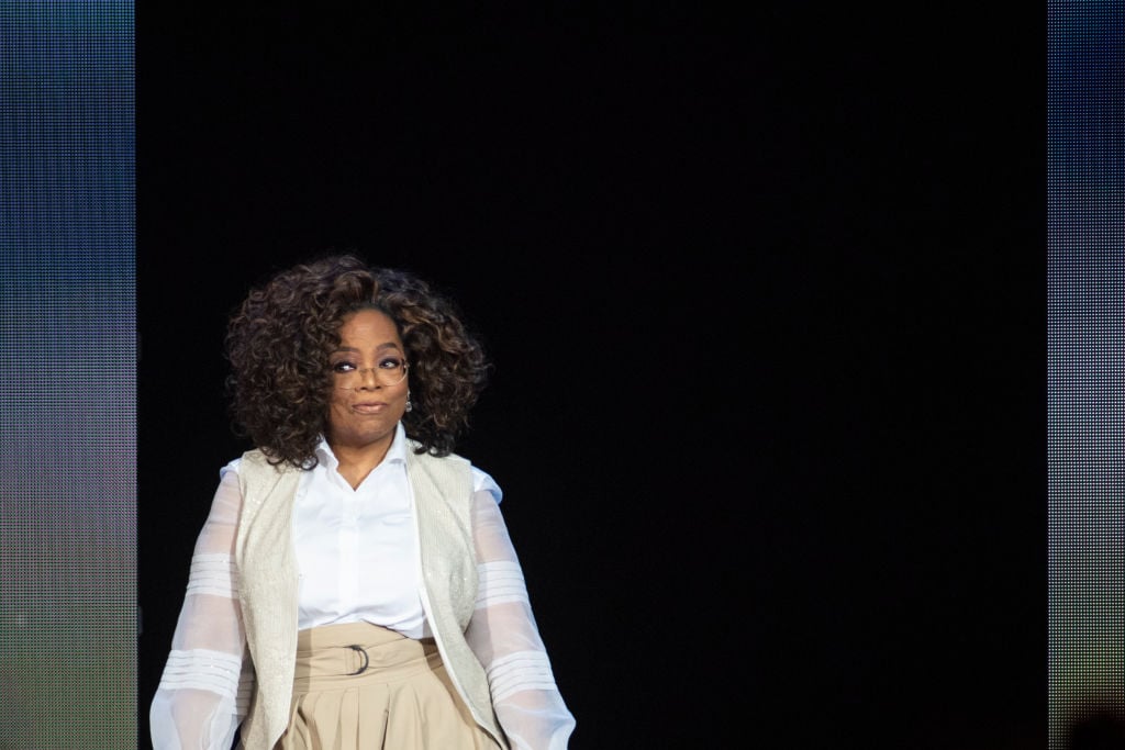 Oprah smiling while walking onto a stage