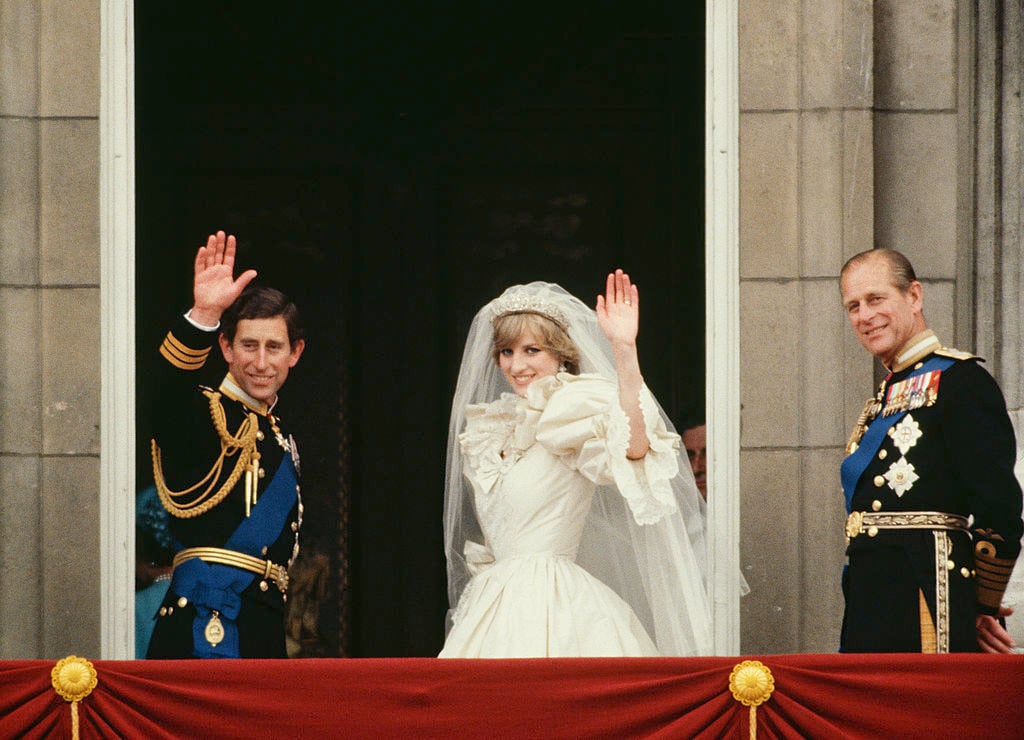 Prince Philip stands next to Prince Charles and Princess Diana wave from the balcony of Buckingham Palace following their royal wedding