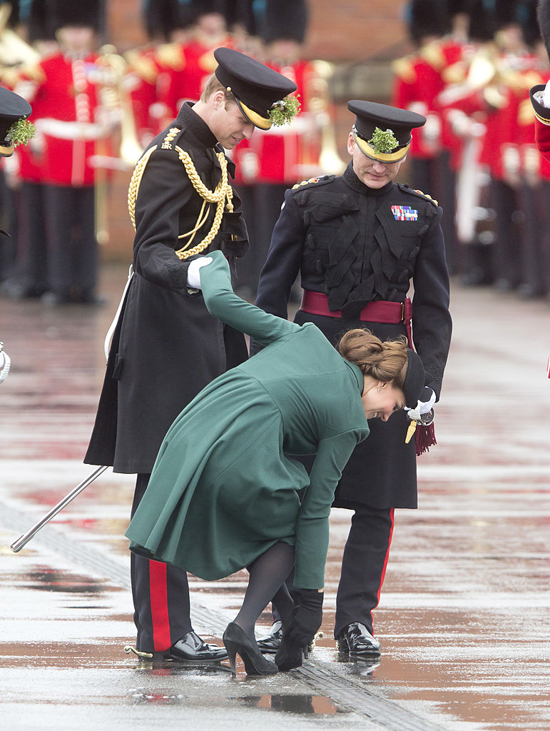 Kate Middleton holds Prince William's hand as she gets her shoe out of a grate