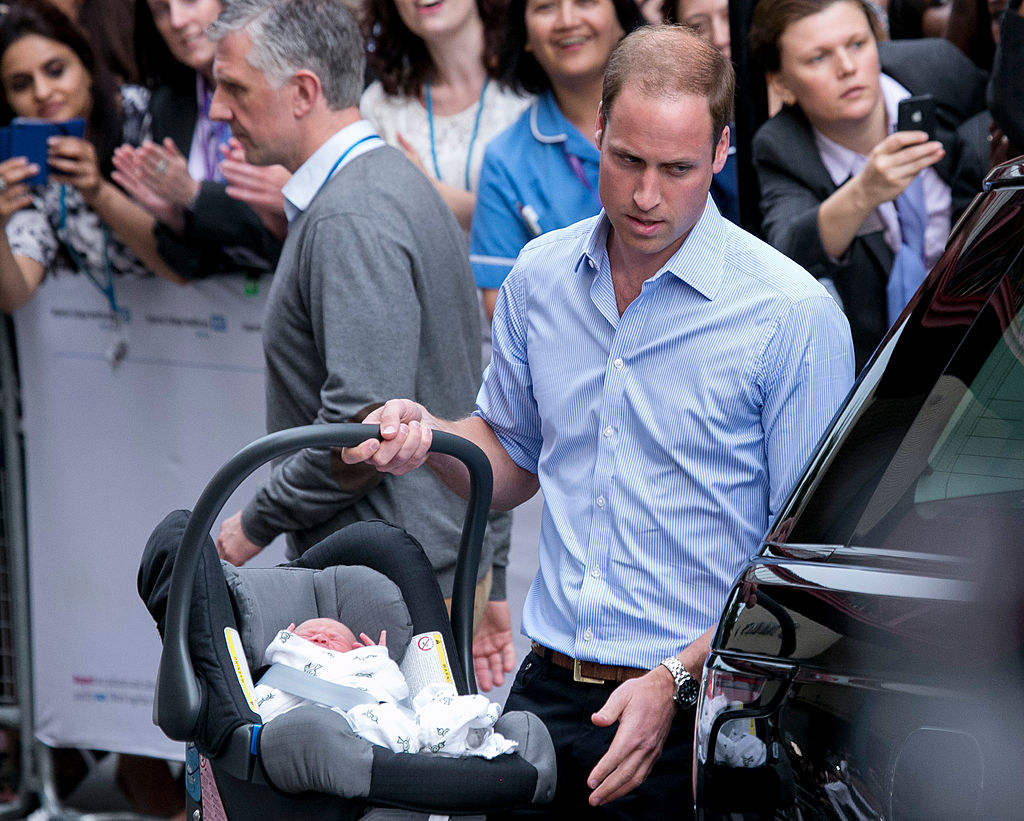 Prince William carries newborn Prince George in car seat before leaving Lindo Wing of St. Mary's Hospital, 2013