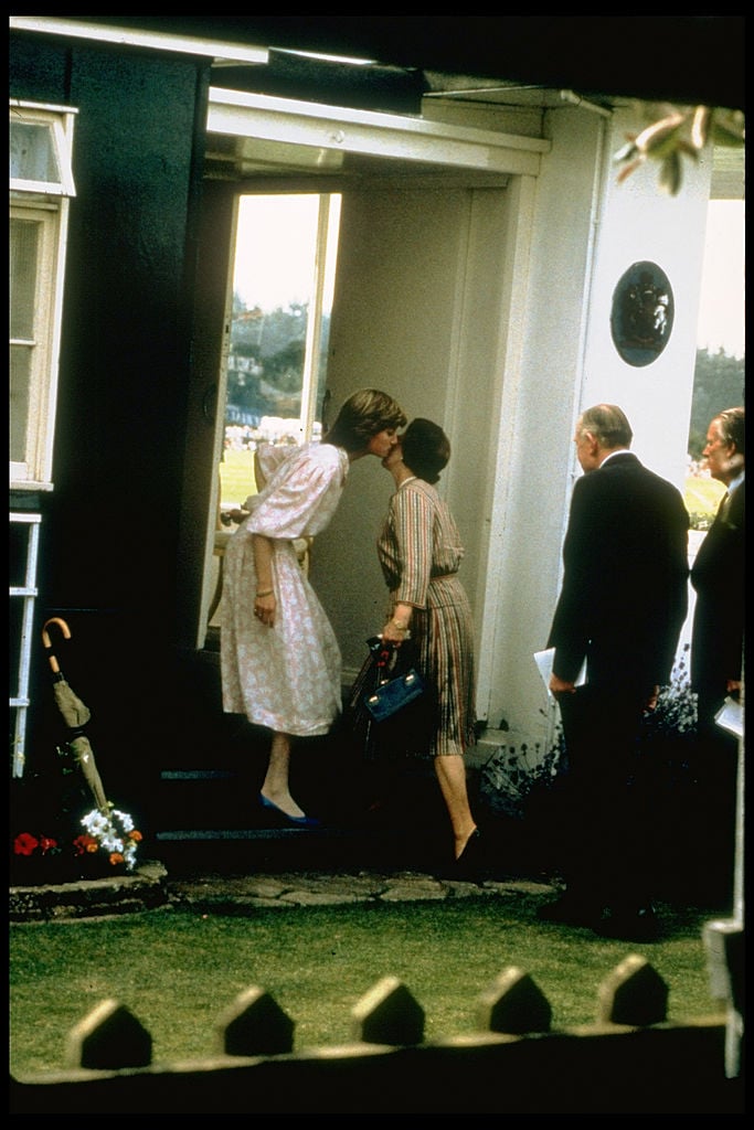 Princess Diana and Queen Elizabeth II kiss on the cheek before watching Prince Charles play polo