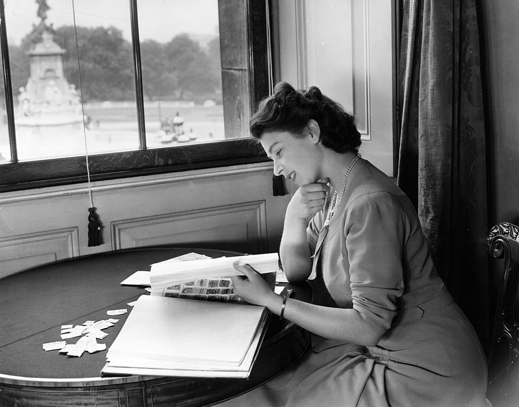 Queen Elizabeth II looking at royal stamp collection