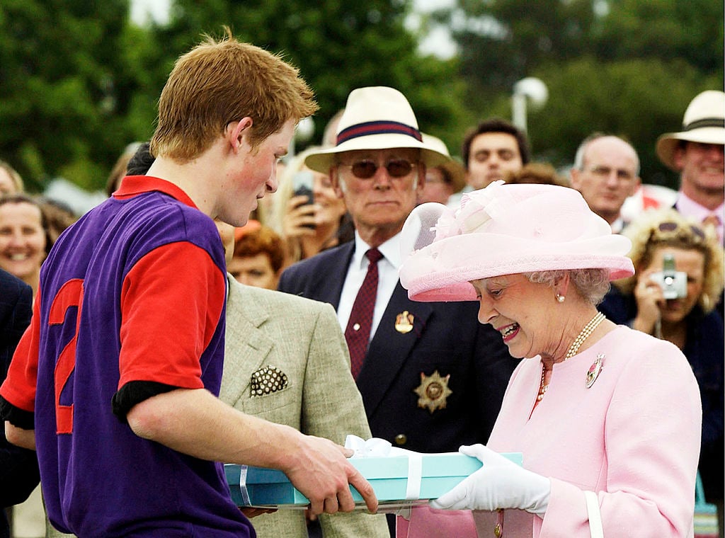Queen Elizabeth presents Prince Harry with a gift after a polo match during Royal Ascot