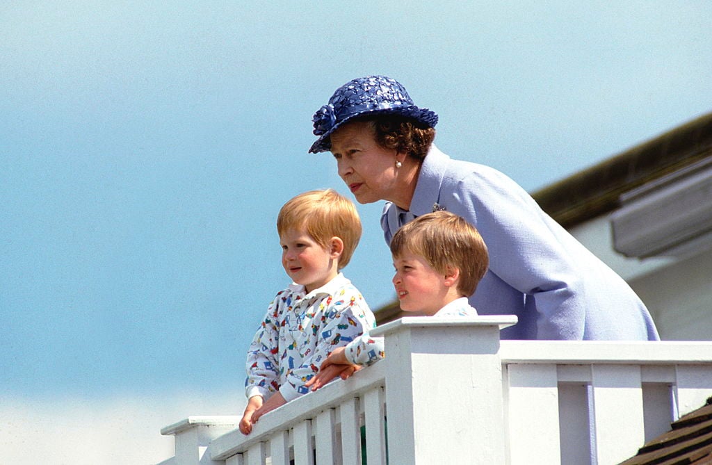 Queen Elizabeth II stands with a young Prince Harry and Prince William at a polo club