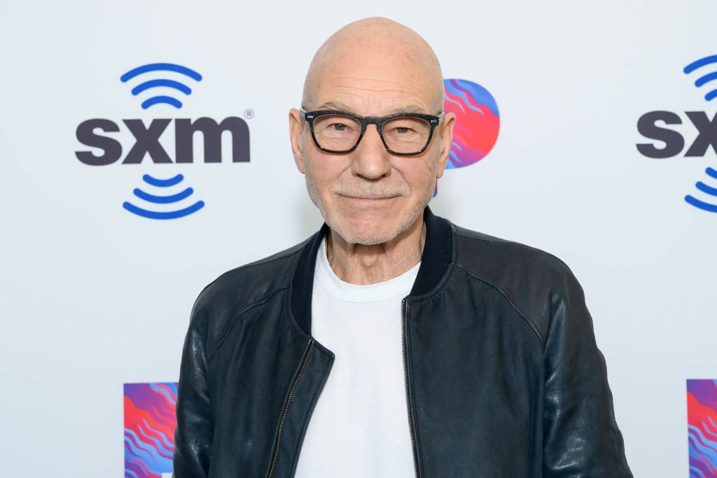 Sir Patrick Stewart smiling in front of a white background