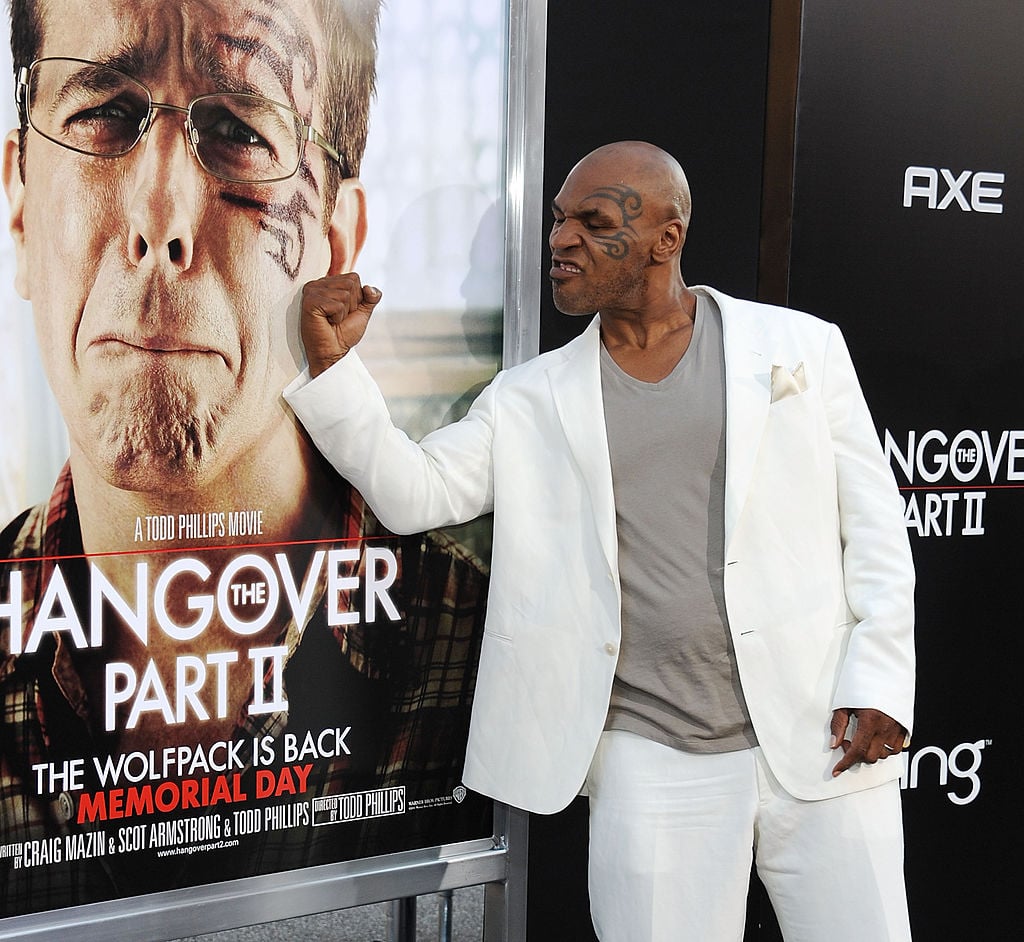 Mike Tyson posing next to a poster for 'The Hangover'