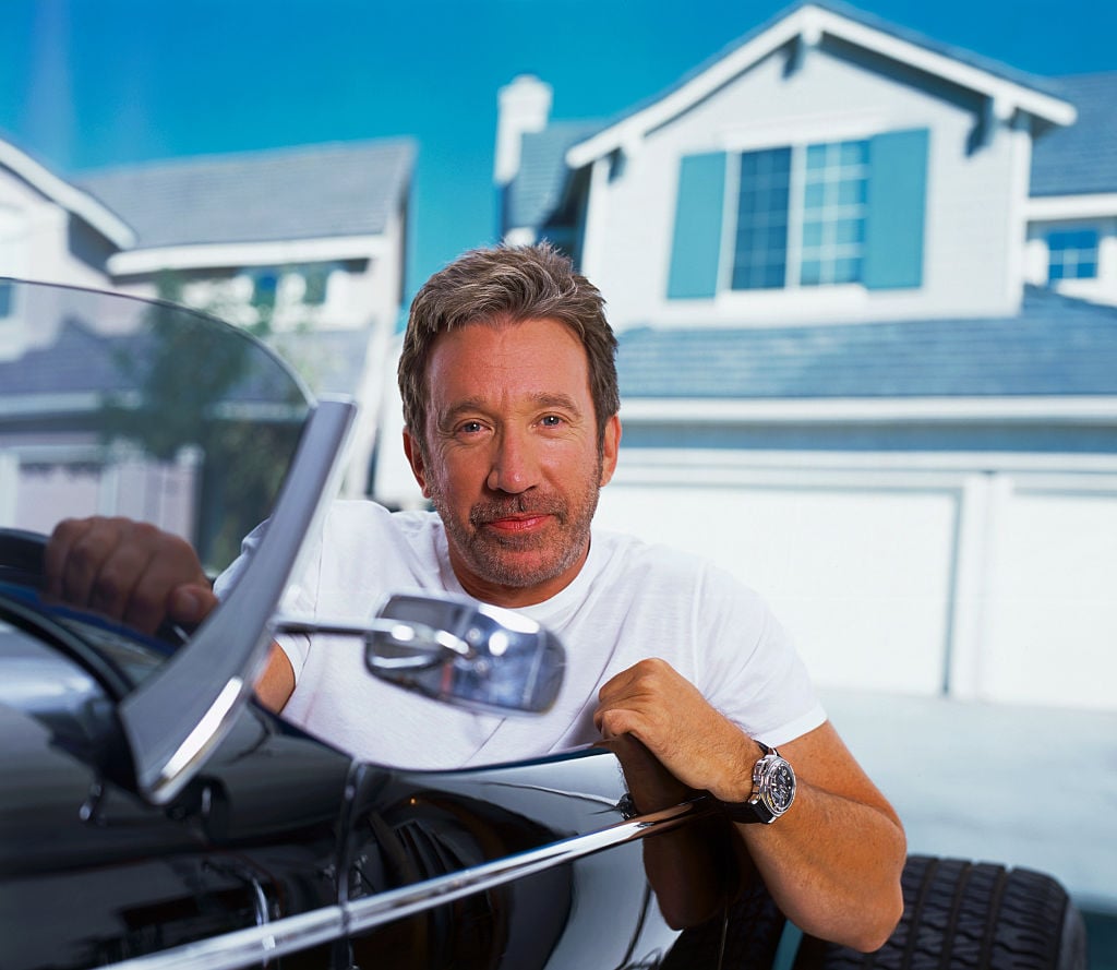 Tim Allen poses for a picture while sitting in a car