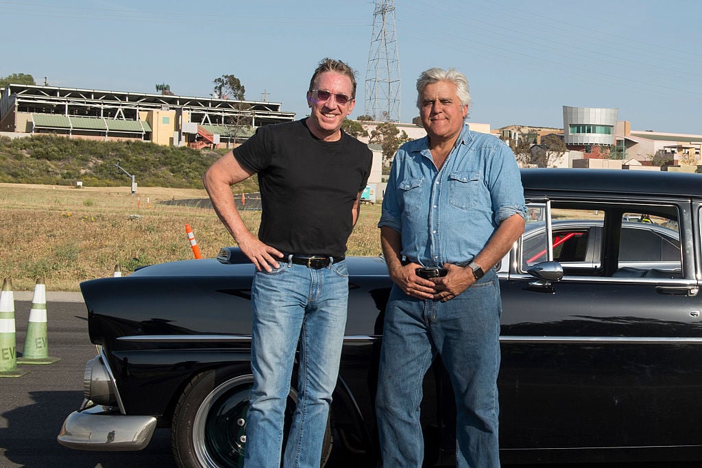 Tim Allen and Jay Leno standing outside smiling in front of a car