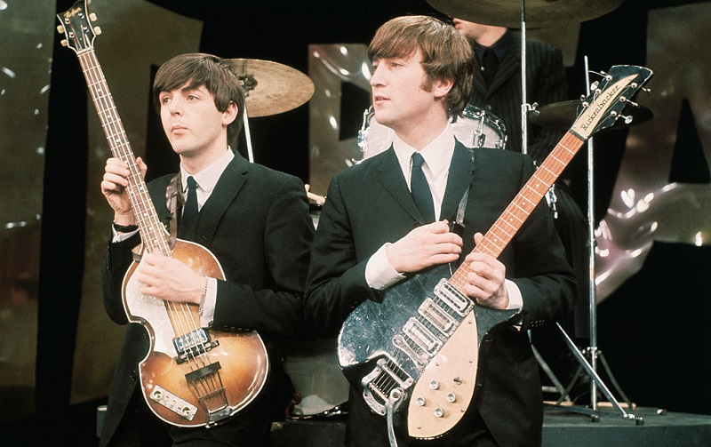 Paul McCartney and John Lennon with their instruments in 1964