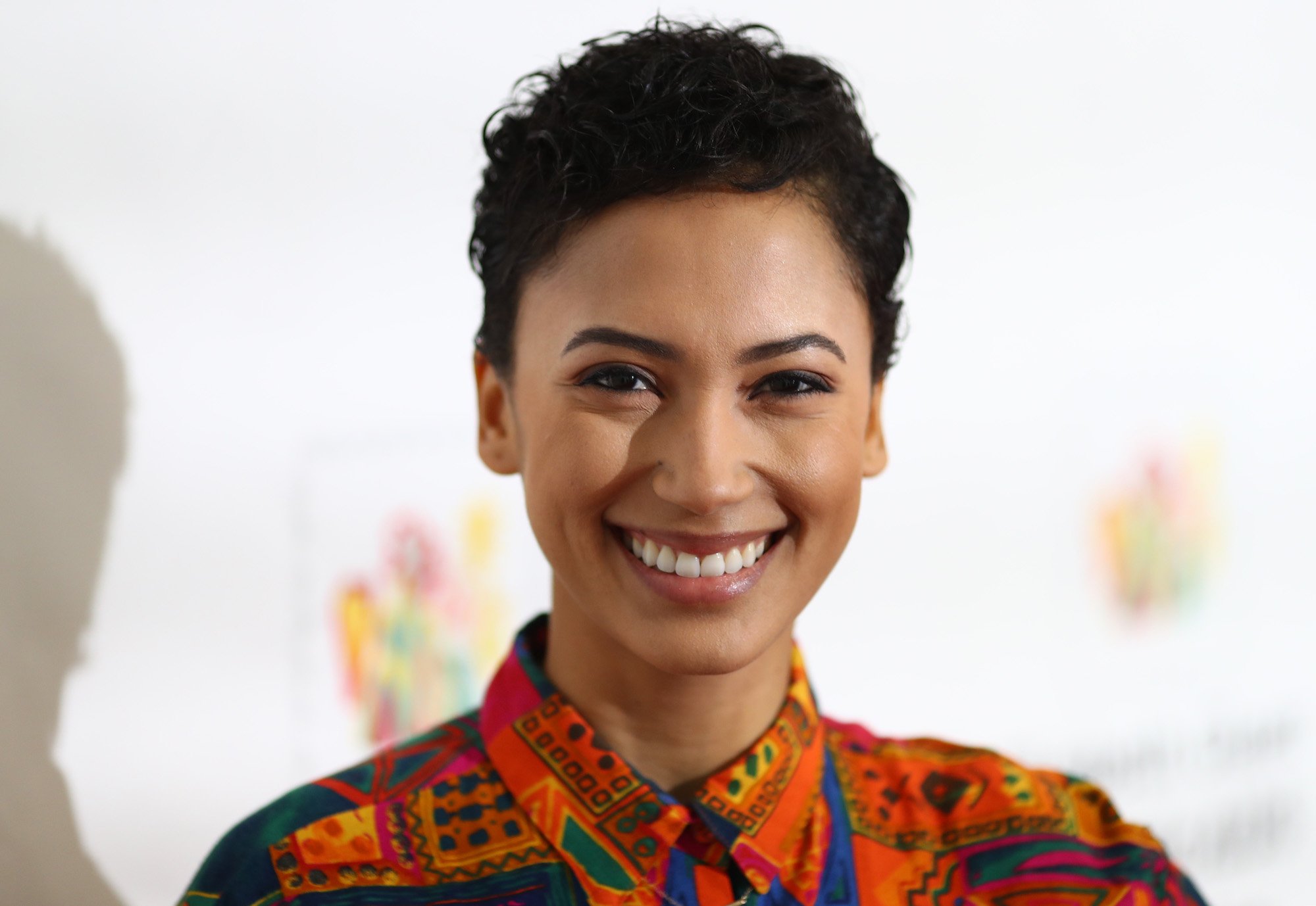 Andy Allo smiling in front of a white background