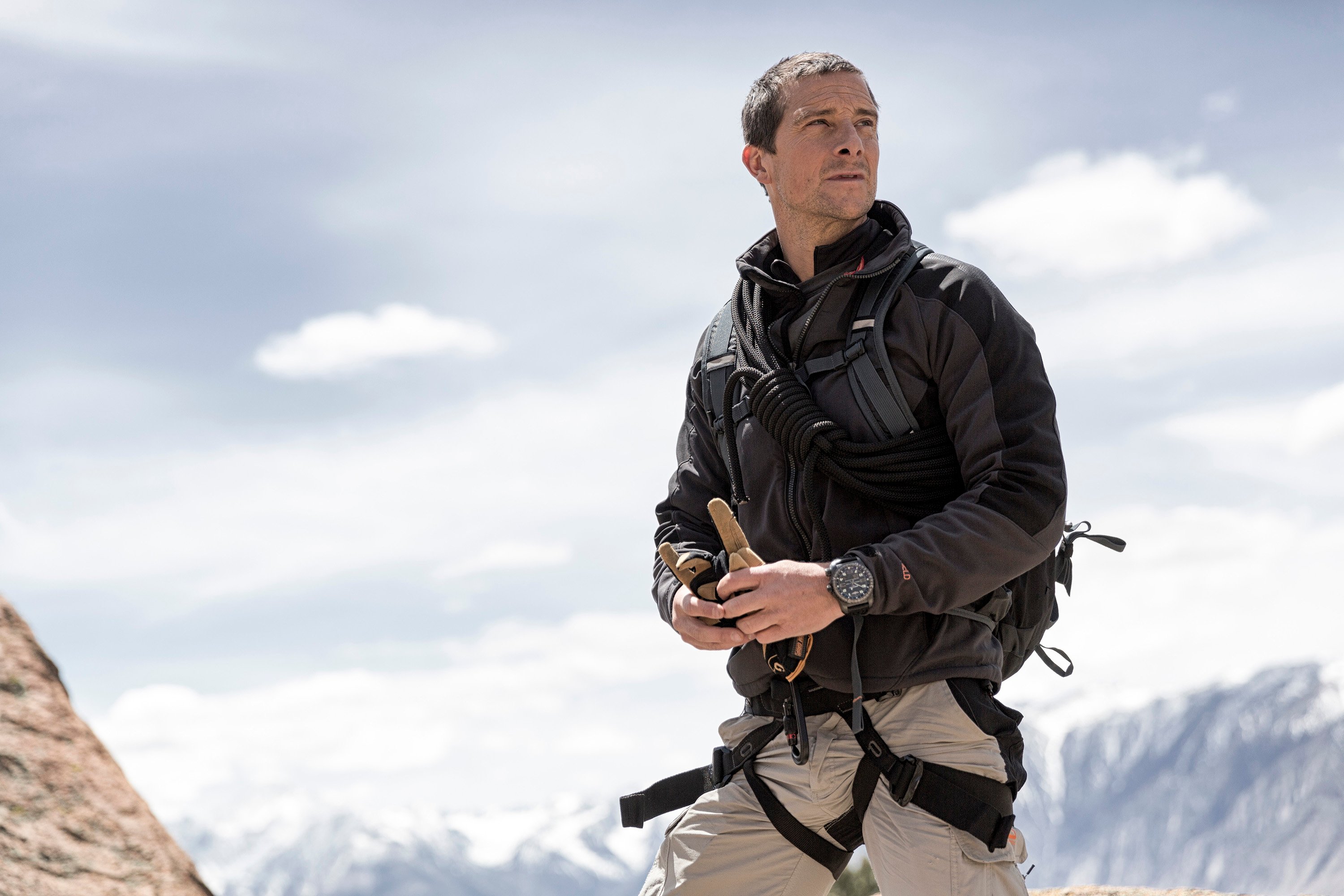Bear Grylls looking on while walking through an icy landscape