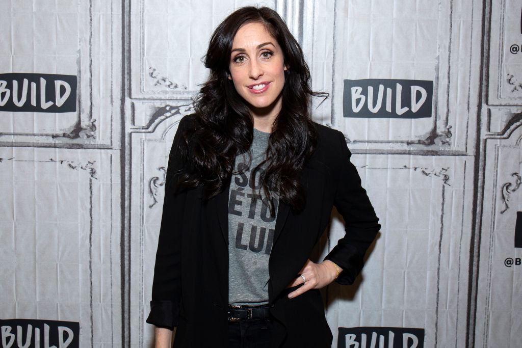Catherine Reitman smiling in front of a textured background