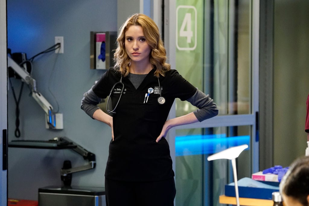 Norma Kuhling as Ava Bekker on 'Chicago Med' standing in scrubs with her hands on her hips in a hospital room