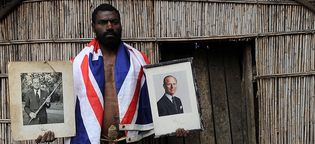 Coorey Sikor Natuan, the son of the local chief, holding portraits of Prince Philip