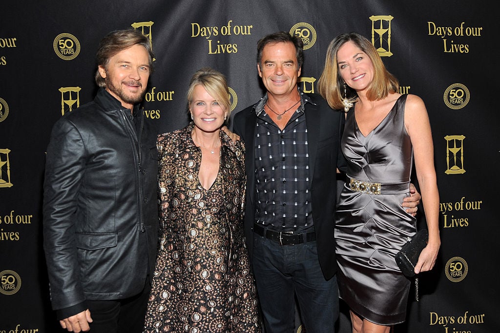 Stephen Nichols, Mary Beth Evans, Wally Kurth, Kassie DePaiva smiling in front of a black backdrop with repeating logo
