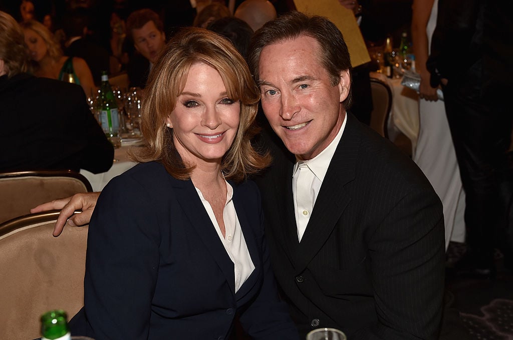 Deidre Hall and Drake Hogestyn smiling, sitting at a dinner table